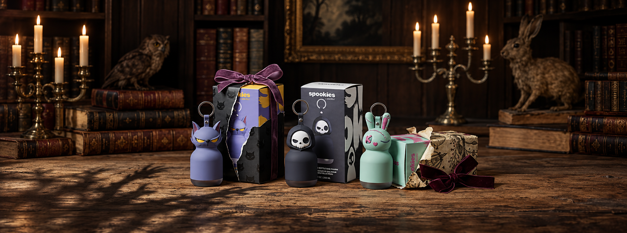 Mini Spookies cat, skeleton and bunny with gift boxes and ribbons in a moody library.